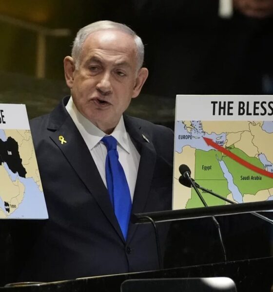 Prime Minister of Israel Benjamin Netanyahu hold signs as he addresses the 79th session of the United Nations General Assembly on Friday.